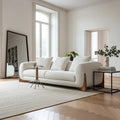 Modern living room with a white sofa, round marble coffee table, and decorative elements.