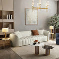 Curved luxury sofa set with ivory upholstery, gold piping, wraparound arms, and premium living room style
