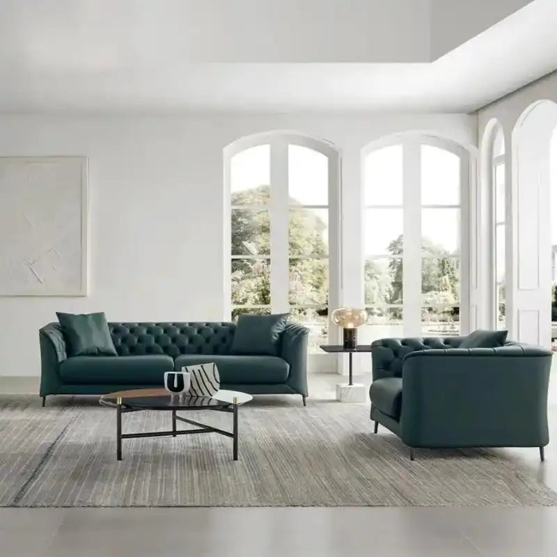 classic dark faux leather sofa with deep button details, high back and broad supportive arms — angled view showing the ful...
