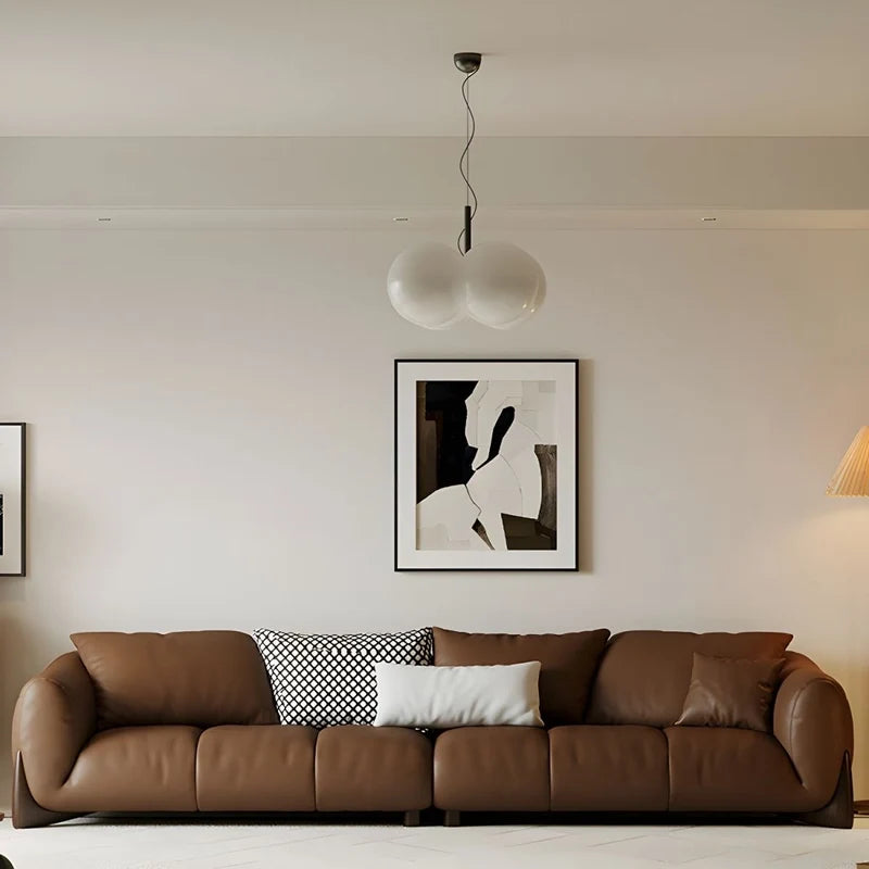 warm brown sofa with deep cushions, soft back support and wide comfortable arms — side angle showing the arms and raised base