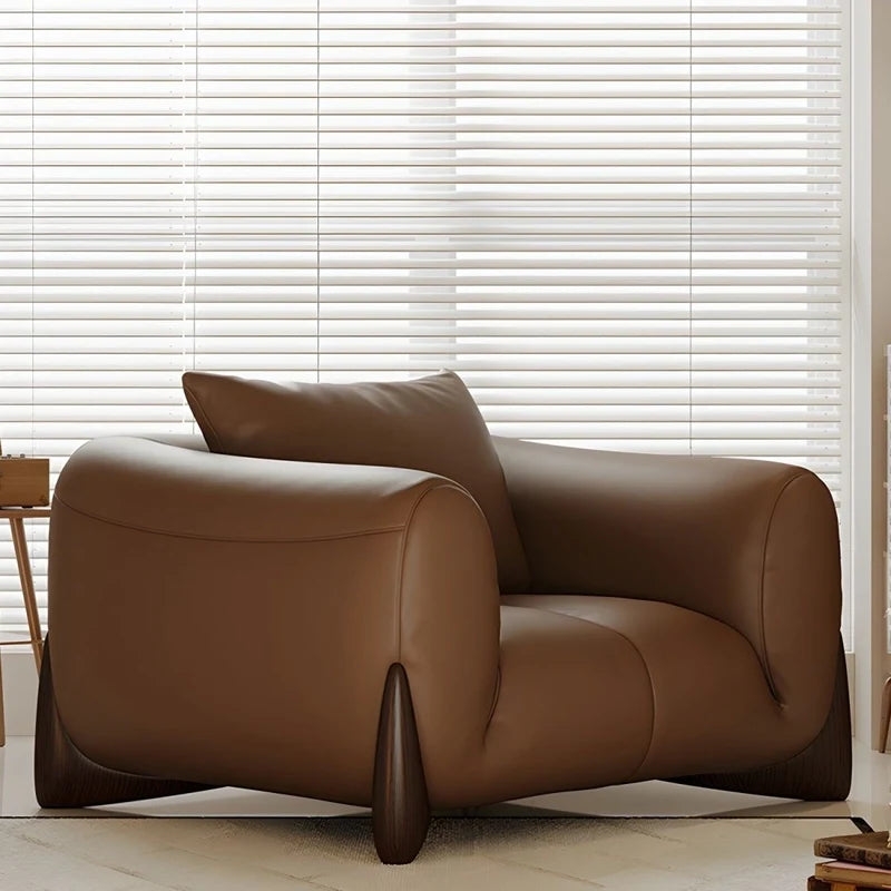 warm brown sofa with deep cushions, soft back support and wide comfortable arms — wide room view showing the complete seat...