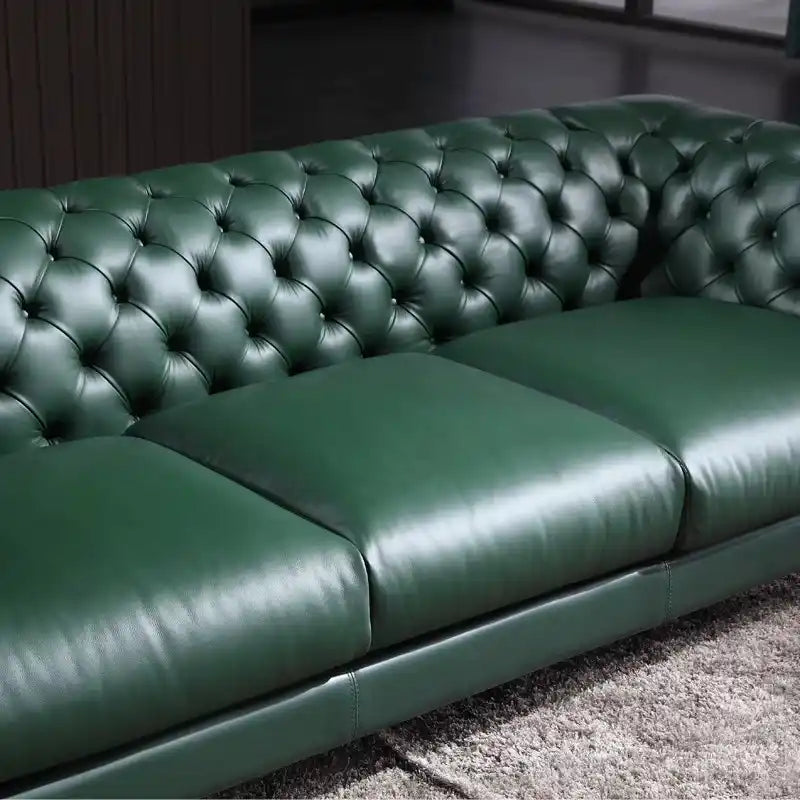 classic dark faux leather sofa with deep button details, high back and broad supportive arms — alternate angle showing the...